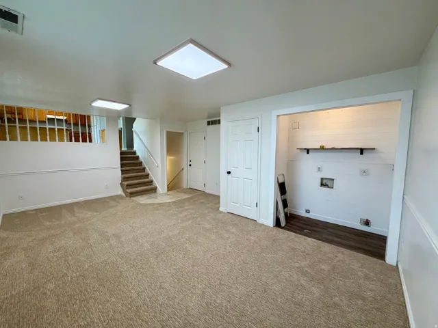 Carpeted lower-level room with recessed lighting