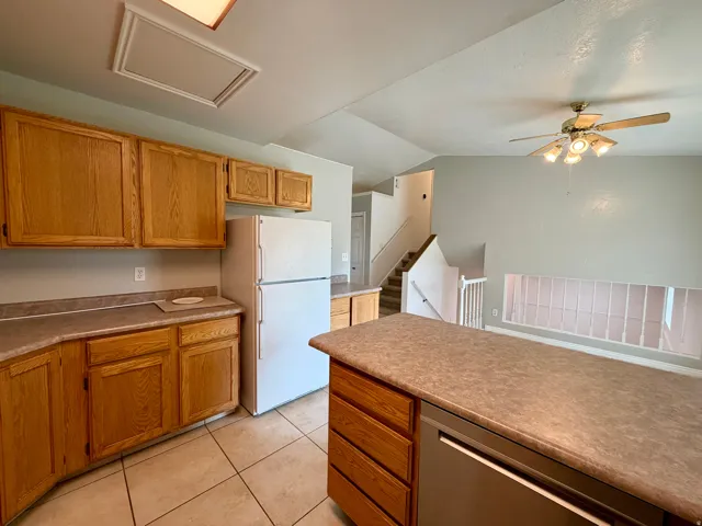Kitchen featuring wood-finish cabinetry, tile flooring, and integrated appliances