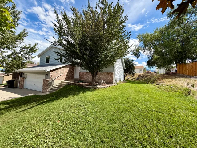 Two-story residence with brick and siding exterior, concrete driveway, and attached garage