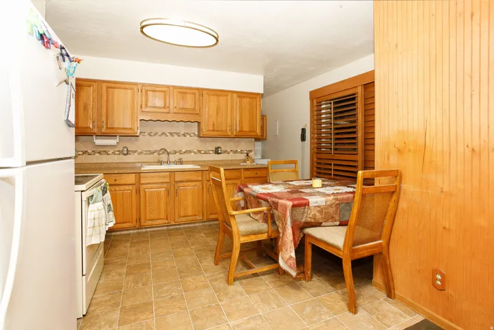 Kitchen featuring wood-finish cabinetry, tile backsplash, and a built-in sink
