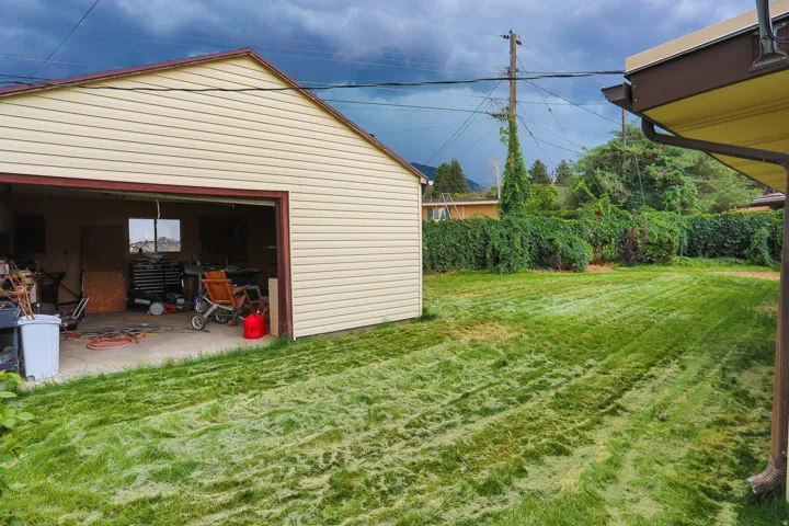 Detached garage with horizontal siding, a single garage door opening, and an exterior window
