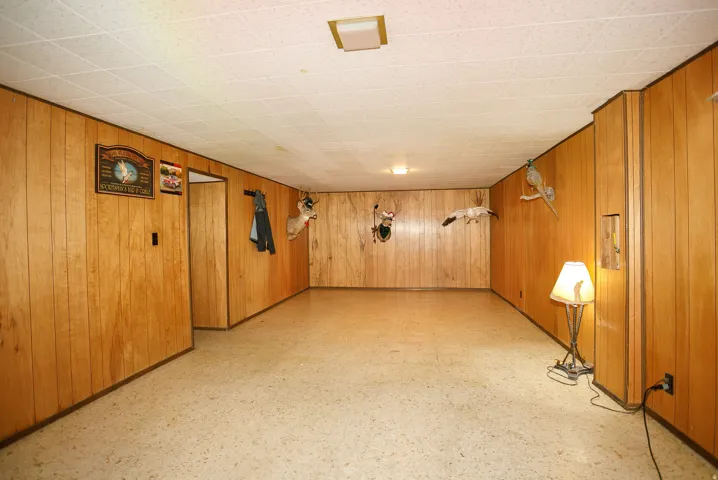 Recessed overhead lighting, paneled wall finishes, light-toned flooring, and a drop ceiling