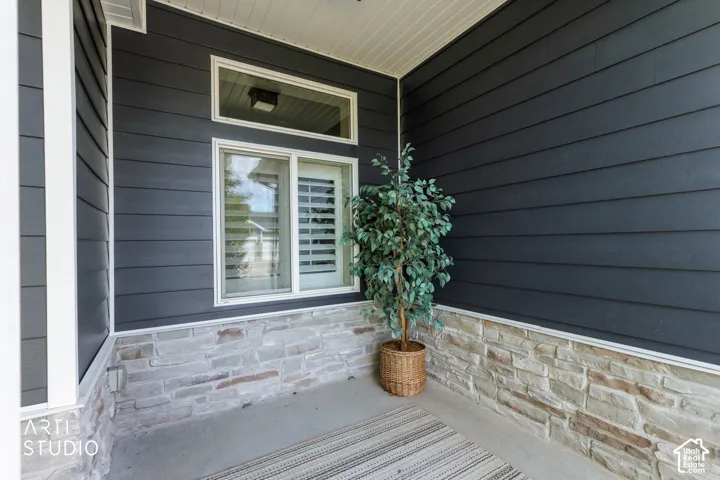 Sleek dark siding combined with a stacked stone facade, white trim, and a transom window