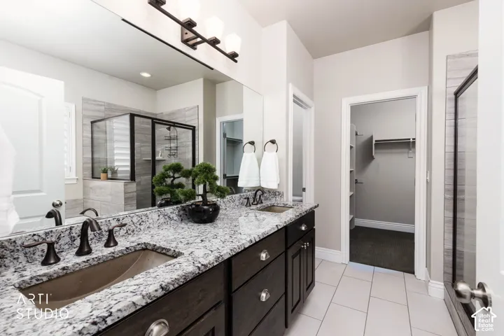 Dual vanity with granite countertops, dark wood-finish cabinetry, and oil-rubbed bronze fixtures