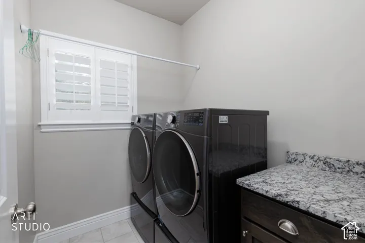 Built-in cabinetry with a light-toned countertop, window with plantation shutters, and a hanging rod