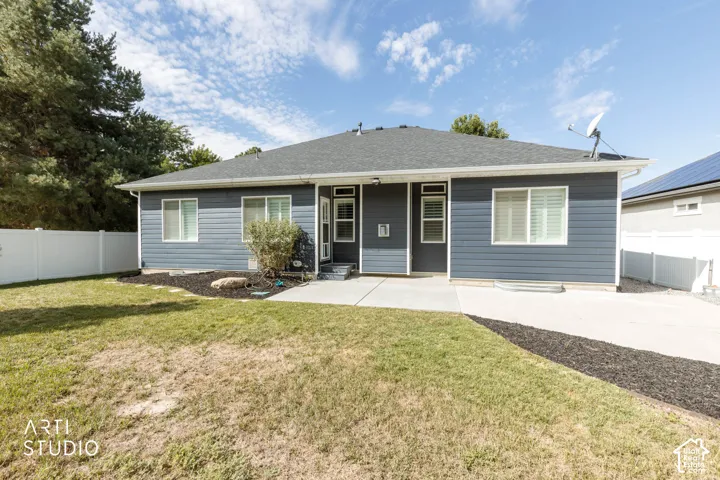 Siding exterior with multiple windows, concrete patio, and a privacy fence
