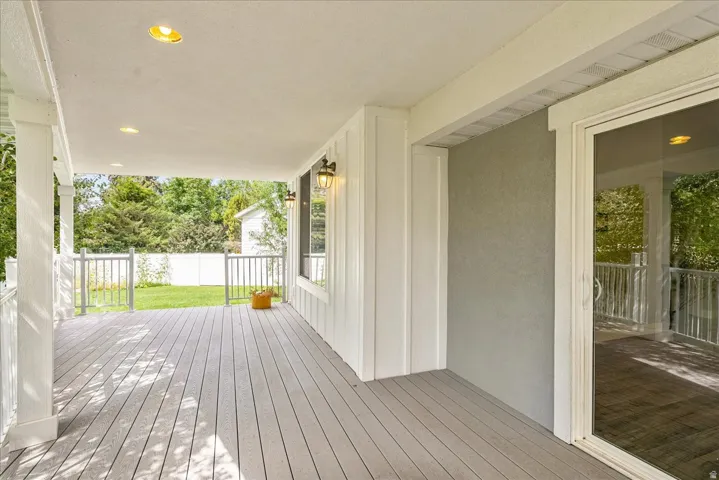 Covered porch featuring recessed lighting, a sliding glass door, and vertical board-and-batten siding