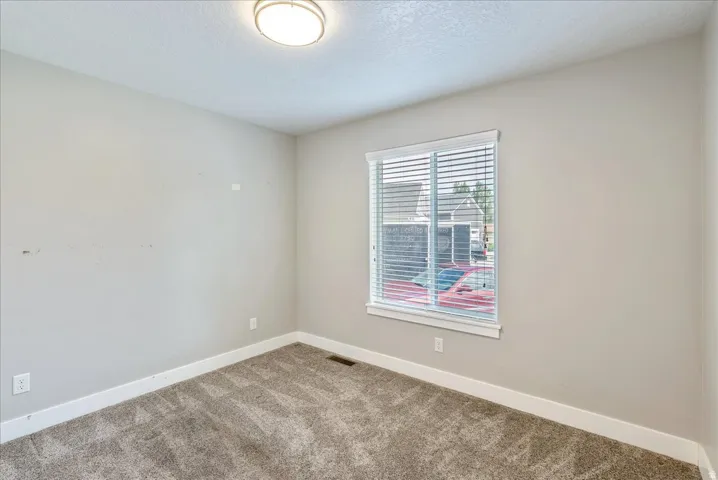 Bright corner bedroom with generous natural light from large double-hung window