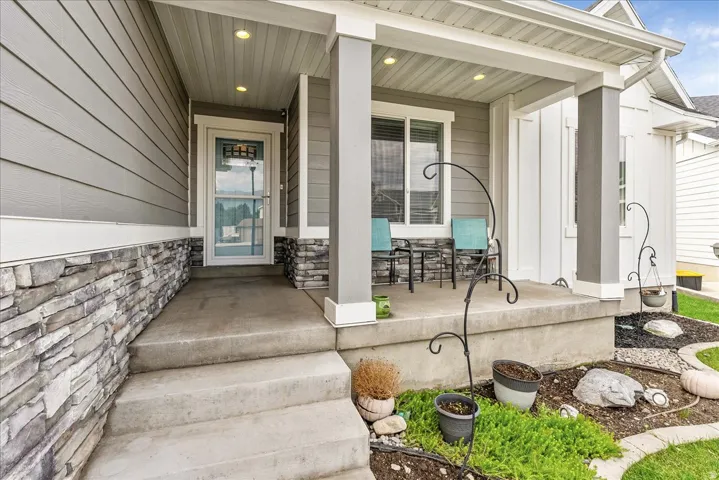 Welcome home to this inviting front entrance featuring a covered porch with substantial white columns, composite decking