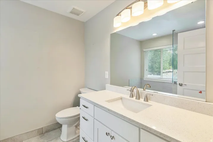 Spa-inspired bathroom featuring a white vanity with dual sinks, quartz countertop, and polished nickel fixtures