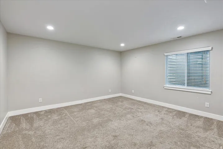 Recessed lighting, light-toned walls, and carpet flooring
