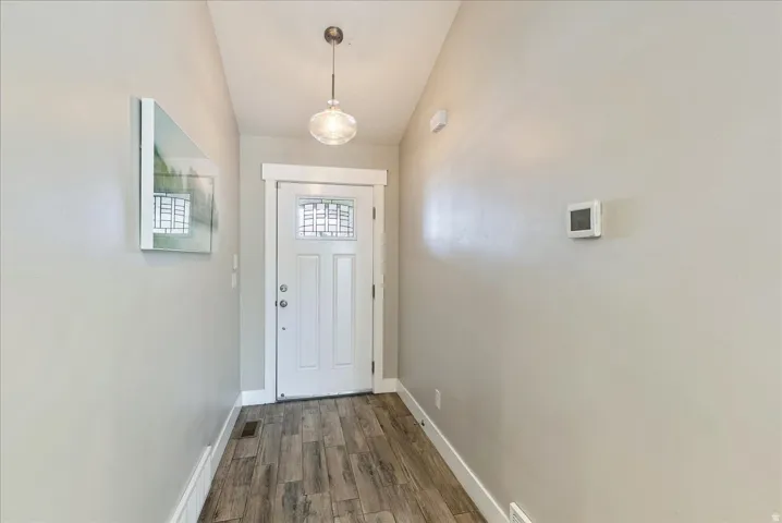 Entryway featuring tile finish flooring, a pendant light fixture, and a white paneled door with decorative glass