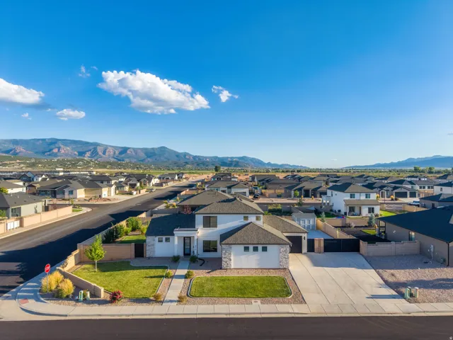 Two-story residence with a two-car garage, concrete driveway, and front lawn