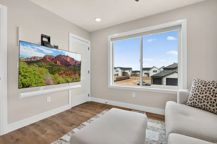 Wood-finish flooring, recessed lighting, and a large window with white trim