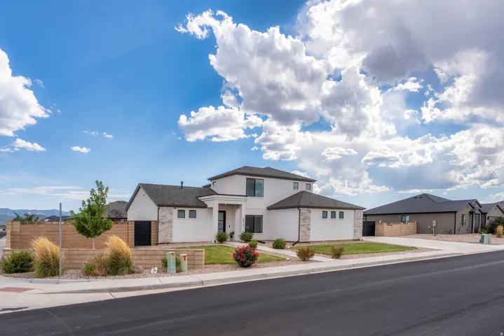 Two-story exterior with a contrasting dark roof and light-colored stucco finish