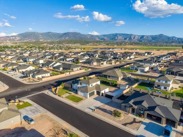 Residential community with a mountain backdrop, featuring paved streets and varied single-family homes