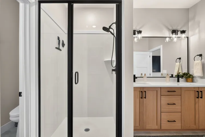 Walk-in shower with black-framed glass enclosure and matte black shower fixtures
