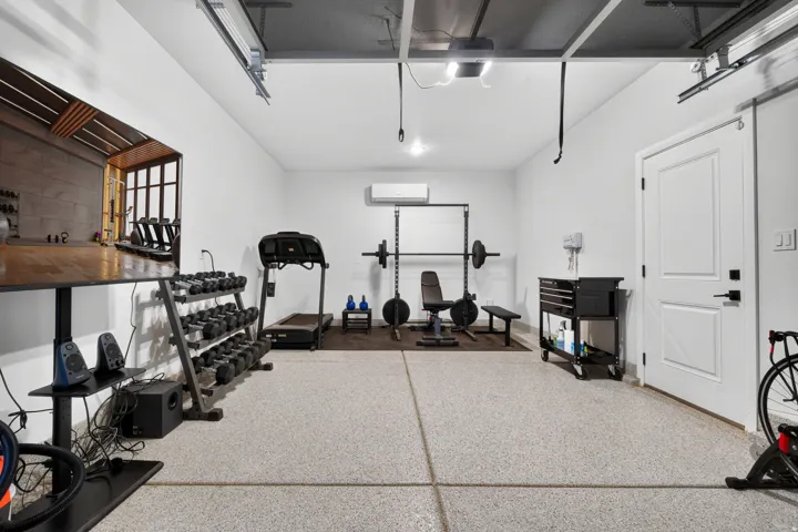 Polished concrete flooring, white walls, and a white paneled door with black hardware