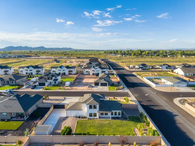 Expansive residential development featuring modern residences, newly paved streets, and mountainous surroundings