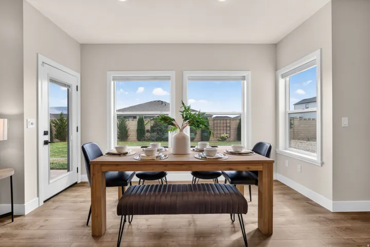 Wood-finish flooring, recessed lighting, multiple windows, white trim, and a glass-paneled exterior door