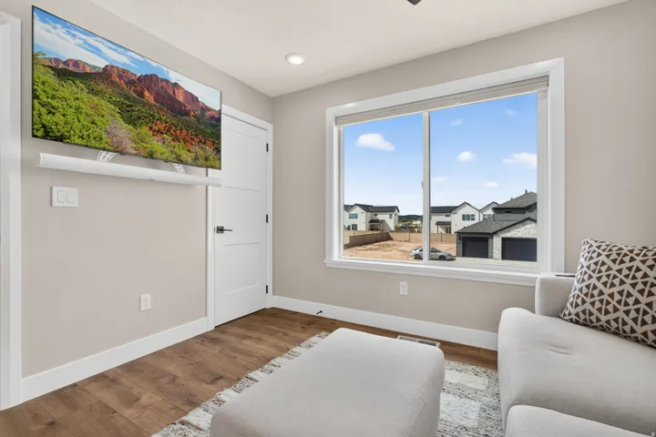 Recessed ceiling lighting, wood-finish flooring, white trim, and a large window