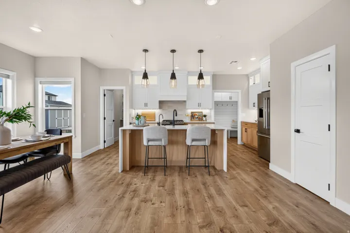 Open-concept living area featuring wood-finish flooring, recessed lighting, and a kitchen island with pendant lights