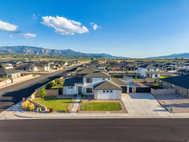 Modern architectural design with a two-car garage and extensive paved driveway