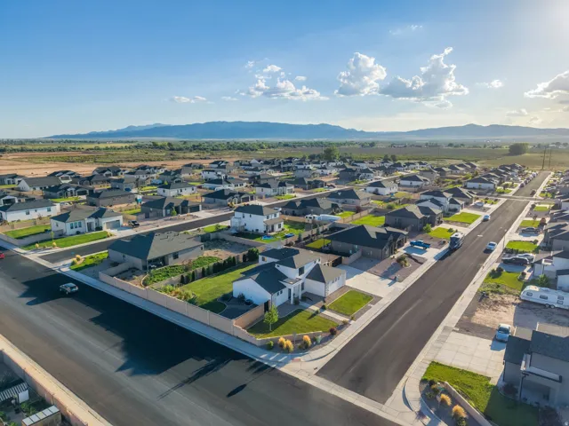 Suburban neighborhood with paved roads, concrete sidewalks, and desert mountain scenery