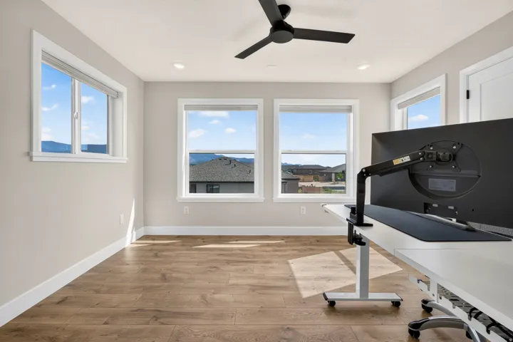 Wood-finish flooring, recessed lighting, and a contemporary ceiling fan