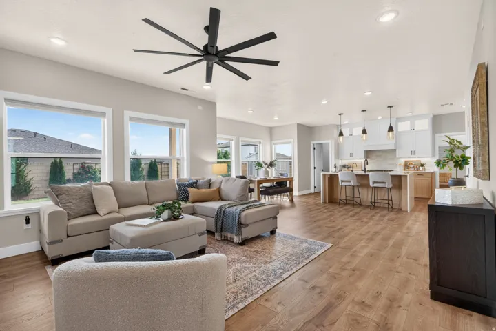 Open-concept living space featuring wood-finish flooring, recessed lighting, and a modern ceiling fan