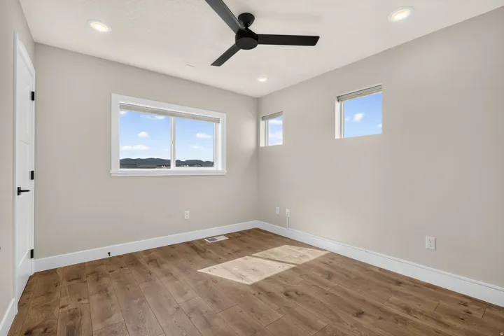 Wood-finish flooring, recessed lighting, and a ceiling fan