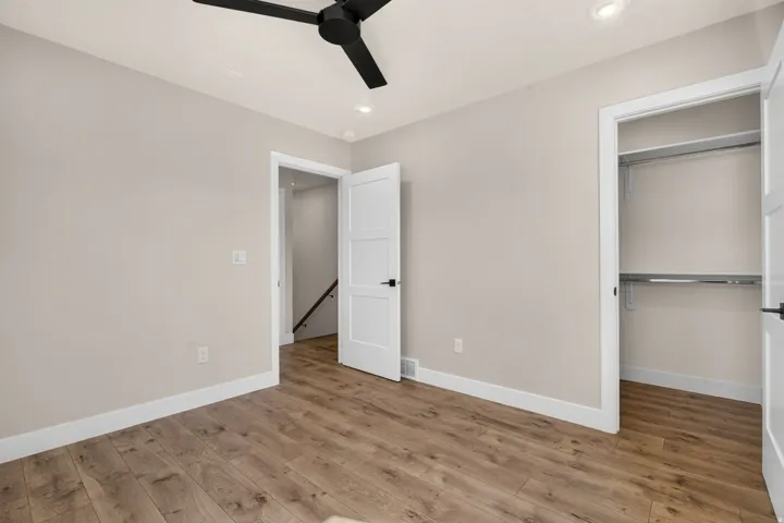 Wood-finish flooring, recessed lighting, and a contemporary ceiling fan
