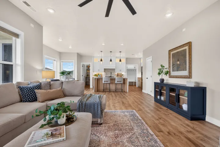 Open-concept living area with wood-finish flooring, recessed lighting, and a ceiling fan