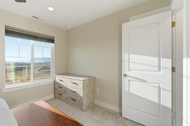 Window with white trim, recessed lighting, and a paneled door