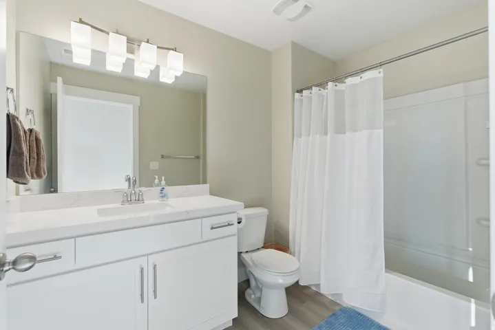 White vanity with integrated sink, chrome faucet, and quartz countertop