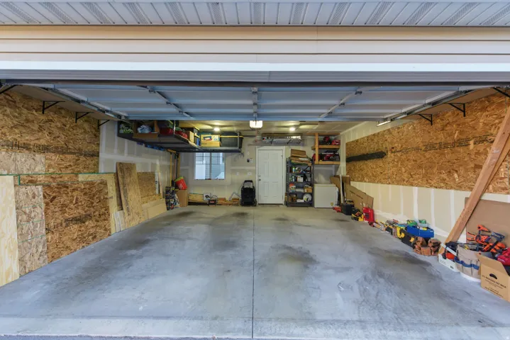 Concrete flooring with overhead lighting, a single window, and a door