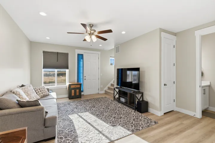 Recessed lighting, wood-finish flooring, ceiling fan, white paneled doors, and white trim throughout