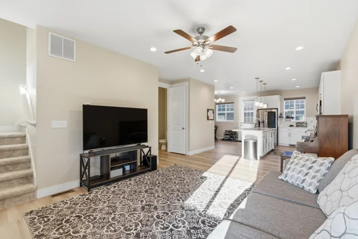 Open-concept living space featuring wood-finish flooring, recessed lighting, and a ceiling fan