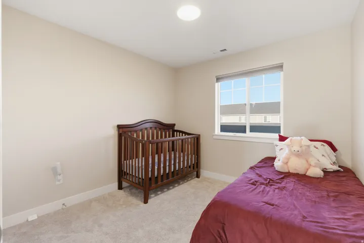 Neutral-toned walls, recessed lighting, carpeted flooring, and a window with white trim
