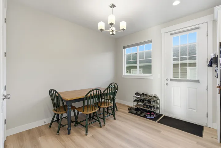 Light wood-finish flooring, white trim, recessed lighting, and a chandelier