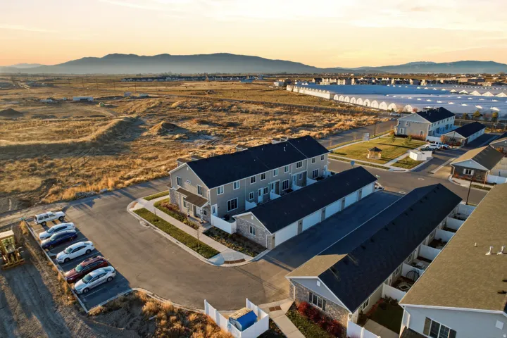 Newly constructed townhomes with durable shingle roofing, integrated garages, and private outdoor spaces