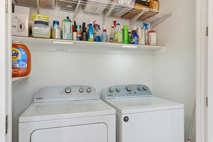 Built-in white wire shelving, overhead shelf with under-shelf lighting, and white walls