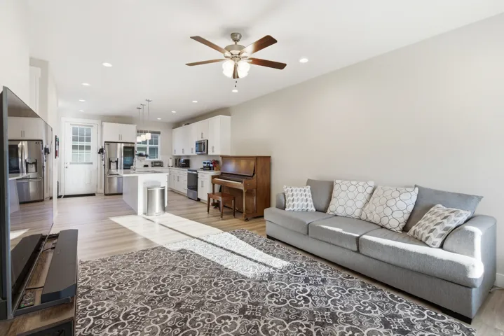Open-concept living space featuring wood-finish flooring, recessed lighting, and a ceiling fan