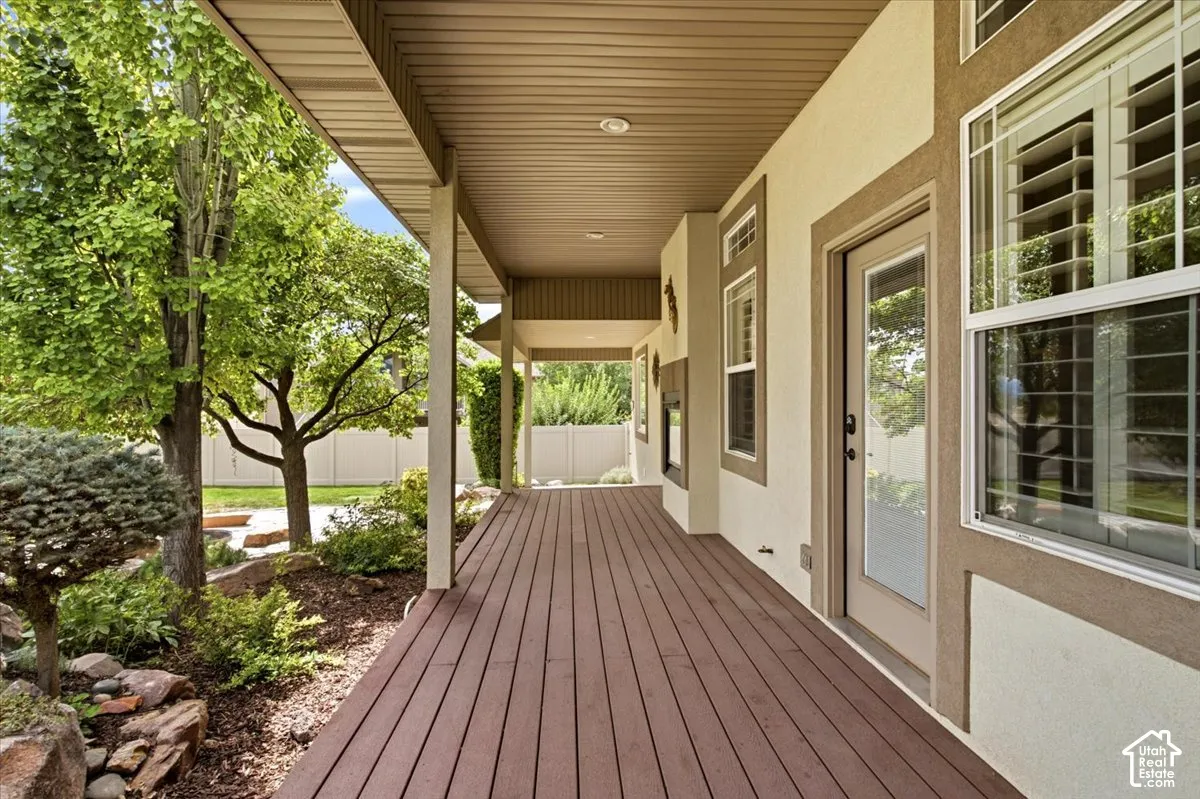 Covered outdoor deck with wood-finish flooring and a gas grill hookup