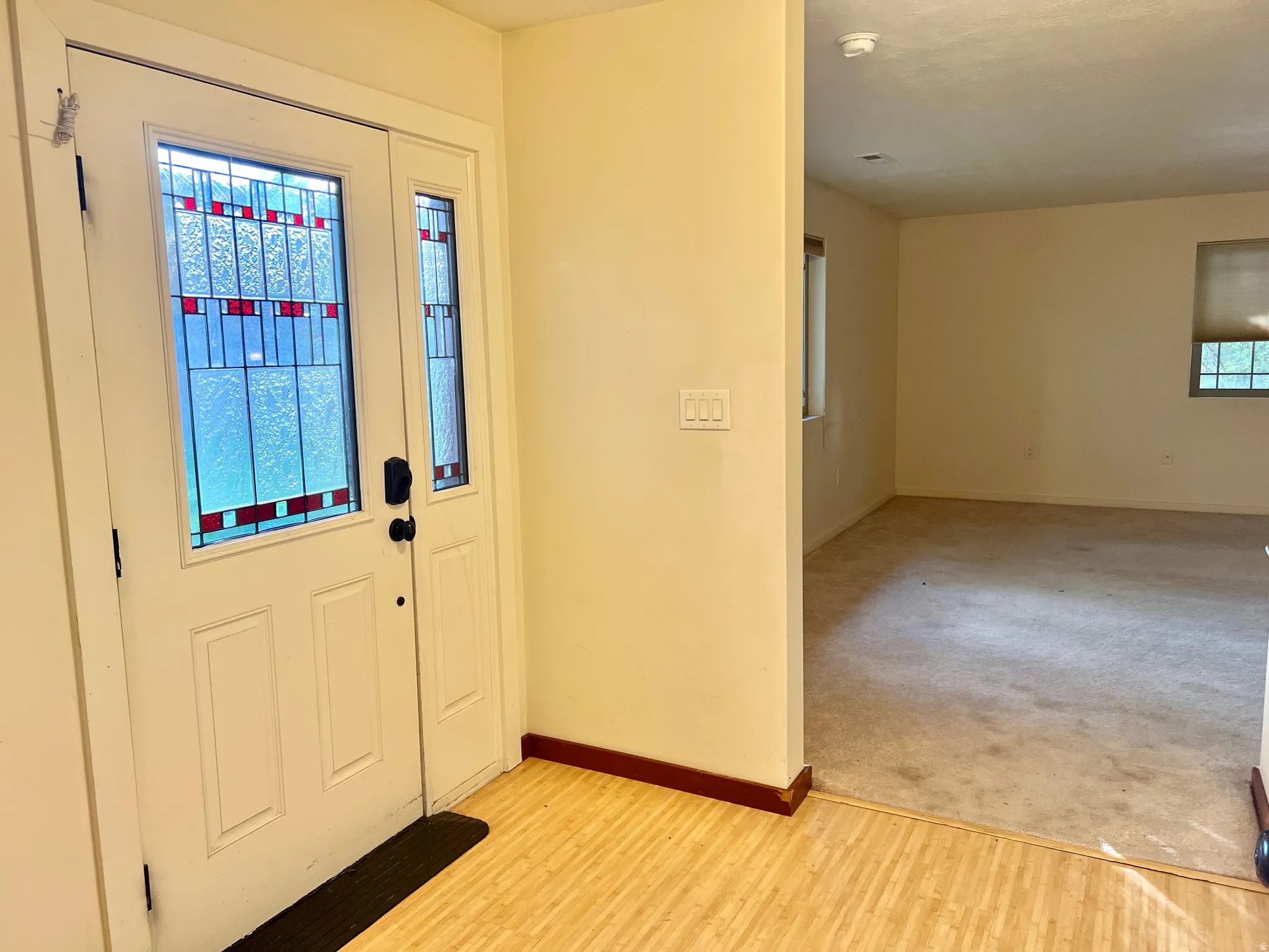 Entryway featuring a white paneled door with stained glass accents and a sidelight