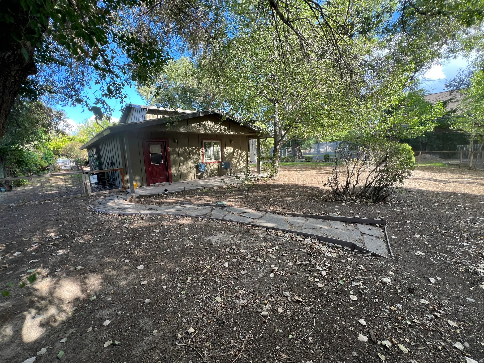 Single-story dwelling with a metal roof, a covered front porch, and a stone-paver walkway