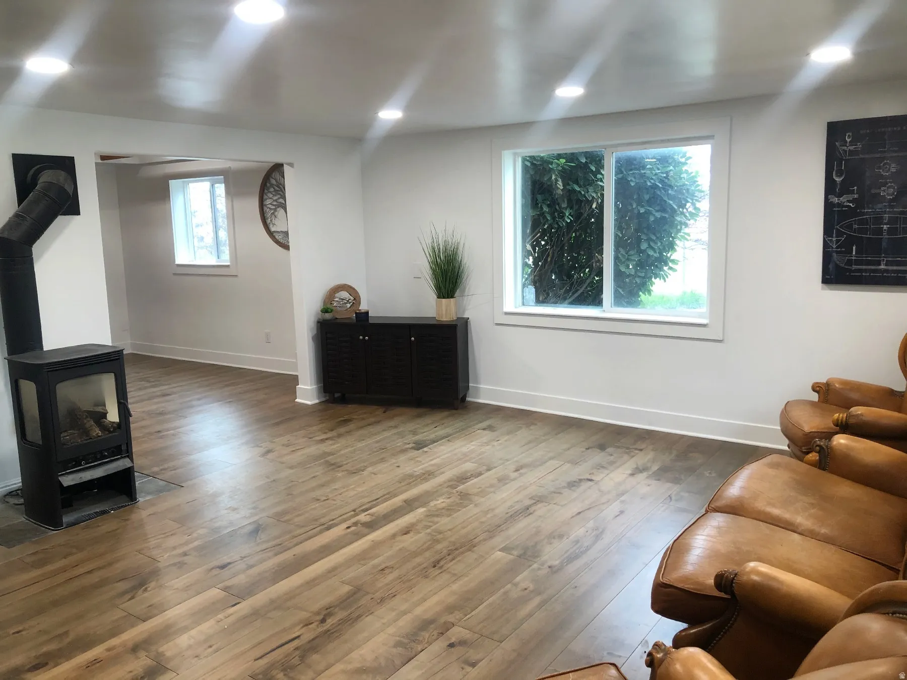 Recessed lighting illuminates wood-finish flooring