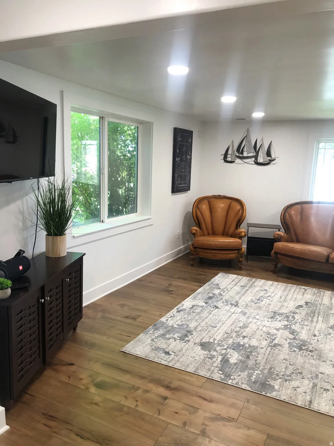 Recessed ceiling lighting illuminates the interior space, featuring wood-finish flooring and white baseboards