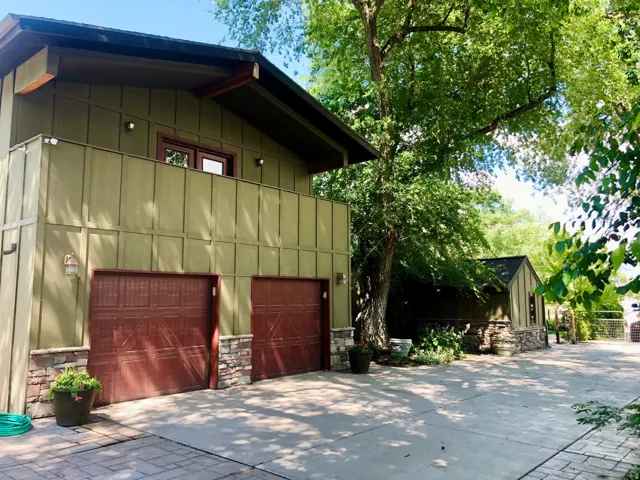 Two-car garage with wood-finish doors and stone accents