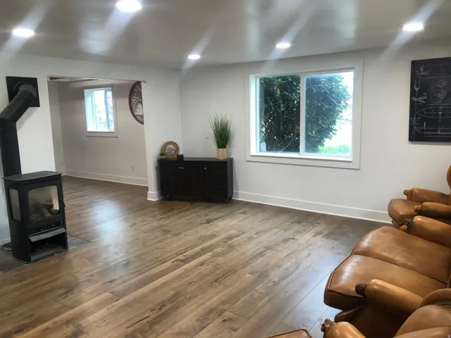 Wood-finish flooring throughout, recessed lighting, and a modern freestanding fireplace